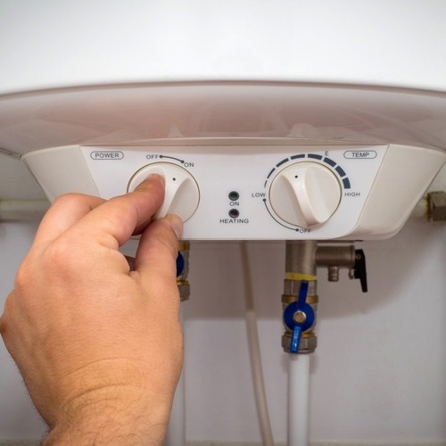 close-up of a man turning on a water heater